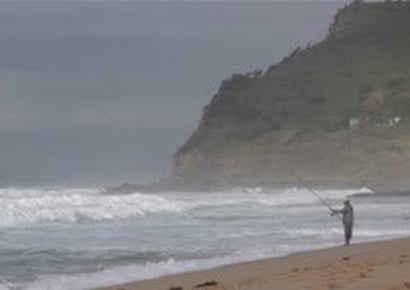 Saltwater surf fishing at beach with spinning reel