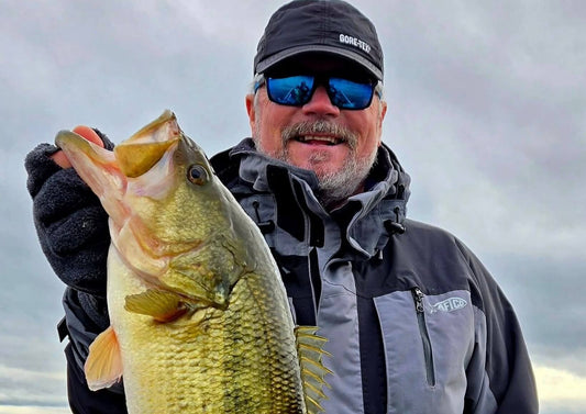 Angler holding a largemouth bass caught during early spring bass fishing