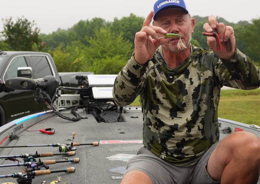 A fishing captain on a boat showing off effective shallow water rigs and gear setups, featuring good bass lures for summer.