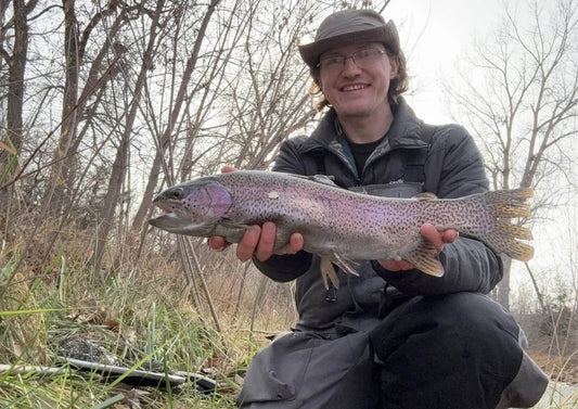Angler fishing for trout using light tackle in a clear river